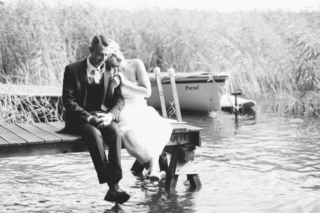 Brautpaar sitzt auf Bootssteg direkt am Hotel Seeterrassen am Wandlitzsee